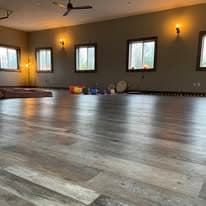 The studio interior with wall sconces, windows, meditation cushions, and singing bowls